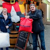 Roswitha Schenkel übergibt dem Gastwirt Norbert Raeder Kleidung und ein Oberbett für bedürftige Menschen