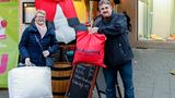 Roswitha Schenkel übergibt dem Gastwirt Norbert Raeder Kleidung und ein Oberbett für bedürftige Menschen