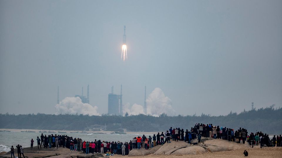 News von heute: China schickt Rakete "Langer Marsch 8" ins All News von heute: "Langer Marsch 8" kurz nach dem Start, Mensch am Strand schauen zu