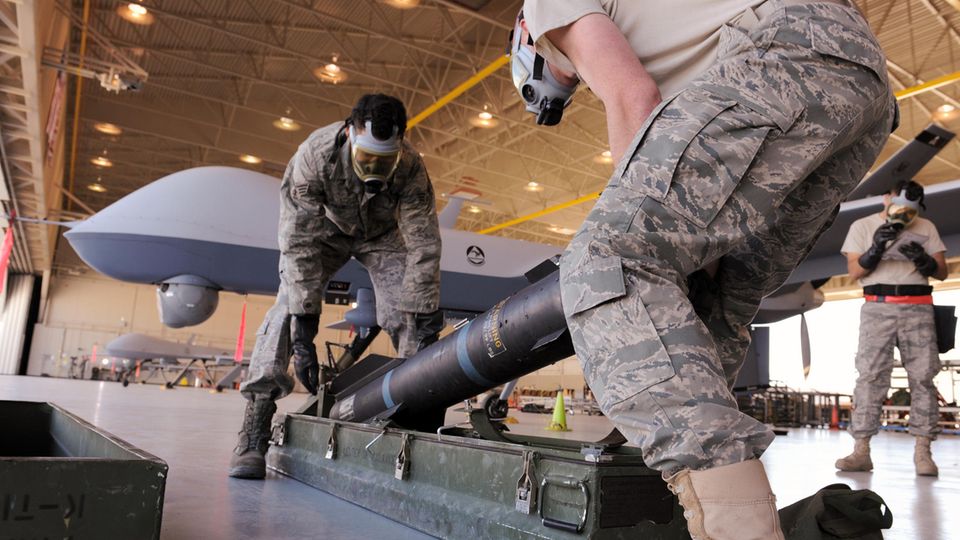 Zwei US-Soldaten munitionieren eine Drohne mit Hellfireraketen.