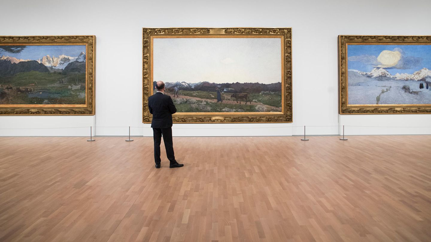 Ein älterer Mann betrachtet Bilder in einem Museum