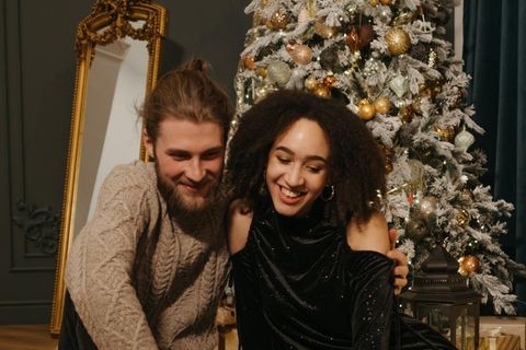 Ein junges Paar vor dem Weihnachtsbaum