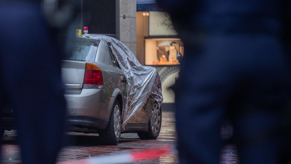 Nachrichten aus Deutschland: Polizisten sichern den Tatort um das demolierte Täterfahrzeug