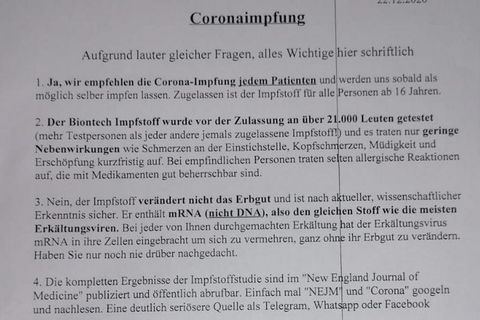 Ein Aushang mit Infos zur Corona-Impfung in einer Arztpraxis