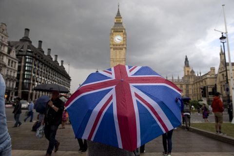 Eine Person mit einem Union-Jack-Regenschirm steht vor Big Ben in London