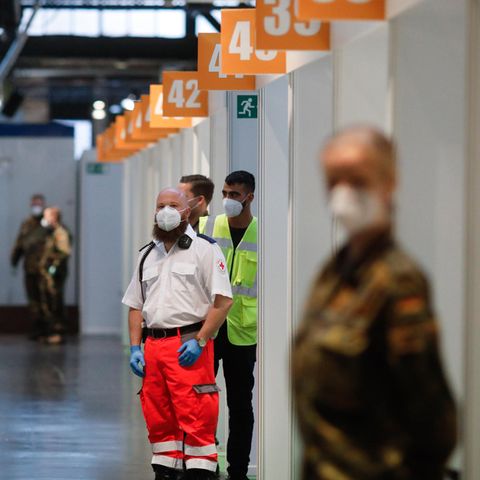 Berlin: Mitarbeiter des Deutschen Roten Kreuzes (DRK), der Bundeswehr und Helfer warten im Impfstoffzentrum Arena Treptow auf den Beginn der Impfungen gegen das Coronavirus