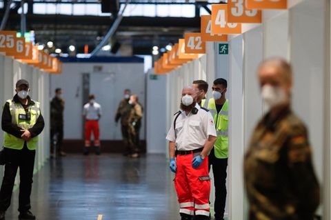 Berlin: Mitarbeiter des Deutschen Roten Kreuzes (DRK), der Bundeswehr und Helfer warten im Impfstoffzentrum Arena Treptow auf den Beginn der Impfungen gegen das Coronavirus