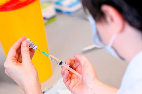 Eine Ärztin zieht ein Spritze mit dem Impfstoff Comirnaty von Biontech/Pfizer auf