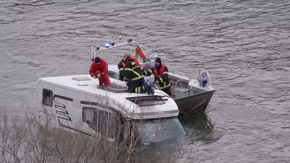 Wohnmobil im Rhein Auf dem Dach eines bis zur Windschutzscheibe im Rhein versunkenen Wohnmobils knien zwei Feuerwehrleute. Daneben ein Boot