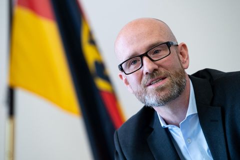 Peter Tauber vor einer Deutschland-Flagge