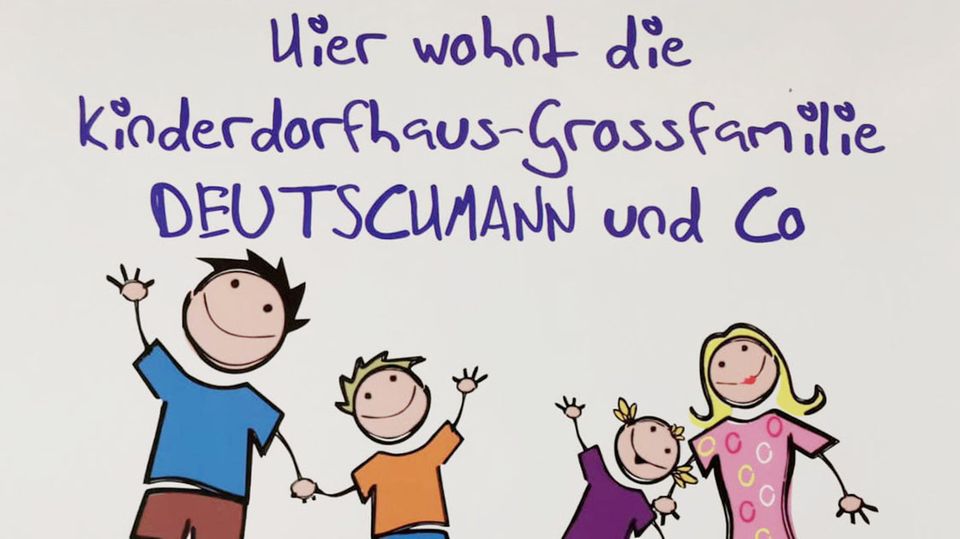 Ein buntes Schild zeigt die Familie als Comicfiguren Ein buntes Schild zeigt die Familie als Comicfiguren