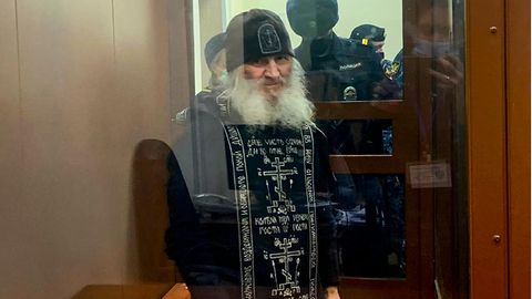 Russland, Moskau: Vater Sergij, Mönch aus Russland, steht vor einer Gerichtssitzung in einem Glaskäfig.