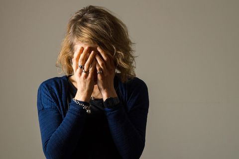 Eine weinende Frau verbirgt ihr Gesicht in den Händen