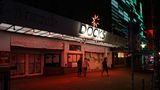 Vor dem geschlossenen Musikklub "Docks" an der Reeperbahn in Hamburg gehen drei junge Männer bei Nacht vorbei