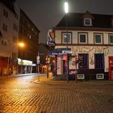 Ein weißes Eckhaus mit ausgeschalteten "Pilsbörse"-Leuchtschildern liegt dunkel da