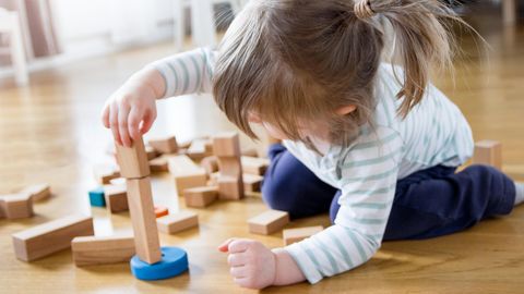 Ein Mädchen spielt mit Holzspielzeug