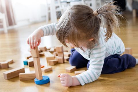 Ein Mädchen spielt mit Holzspielzeug