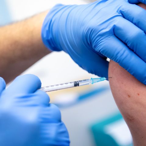 Ein Klinik-Mitarbeiter wird mit dem Corona-Impfstoff von Biontech/Pfizer geimpft