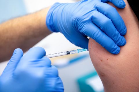 Ein Klinik-Mitarbeiter wird mit dem Corona-Impfstoff von Biontech/Pfizer geimpft