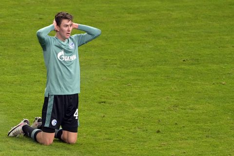 Ein Fußballer im türkisen Trikot und schwarzer Hose kniet auf dem Rasen und schlägt die Hände über dem Kopf zusammen