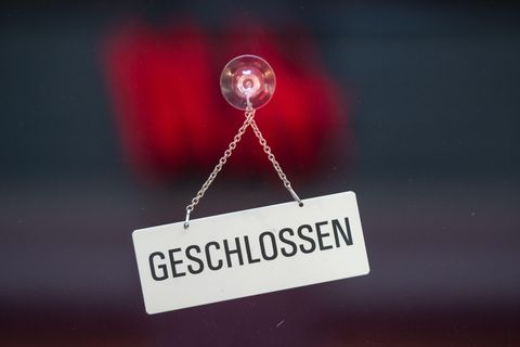Ein Schild mit der Aufschrift "Geschlossen" ist mit einem Saugnapf an einer Glastür befestigt
