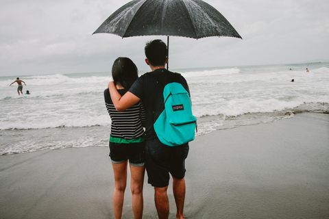 Ein Paar steht bei Sturm an einem Strand