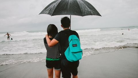 Ein Paar steht bei Sturm an einem Strand