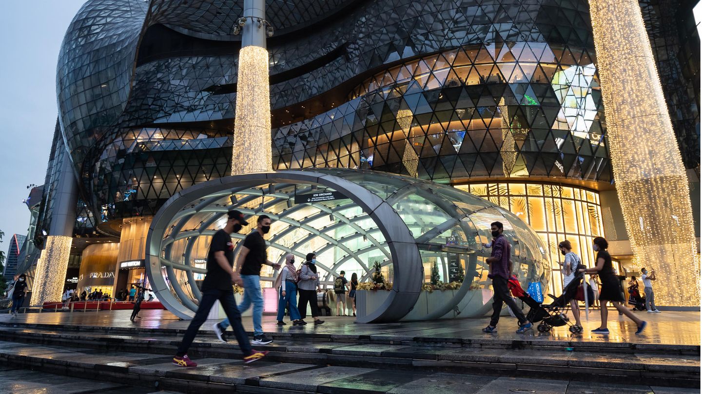 Menschen vor einem Einkaufszentrum in Singapur Menschen vor einem Einkaufszentrum in Singapur