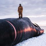 Ein Dorfbewohner auf einem erlegten Grönlandwal