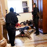 Mit vorgehaltener Waffe hält die Kapitolpolizei Angreifer in der Nähe des Plenarsaals fest