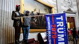 Dieser Randalier macht klar, für wen er in das Kapitol eingedrungen ist: Er hat einer Statue im Inneren des Gebäudes eine Trump-Mütze aufgesetzt und eine Fahne mit dem Namen des abgewählten Präsidenten in den Arm gelegt