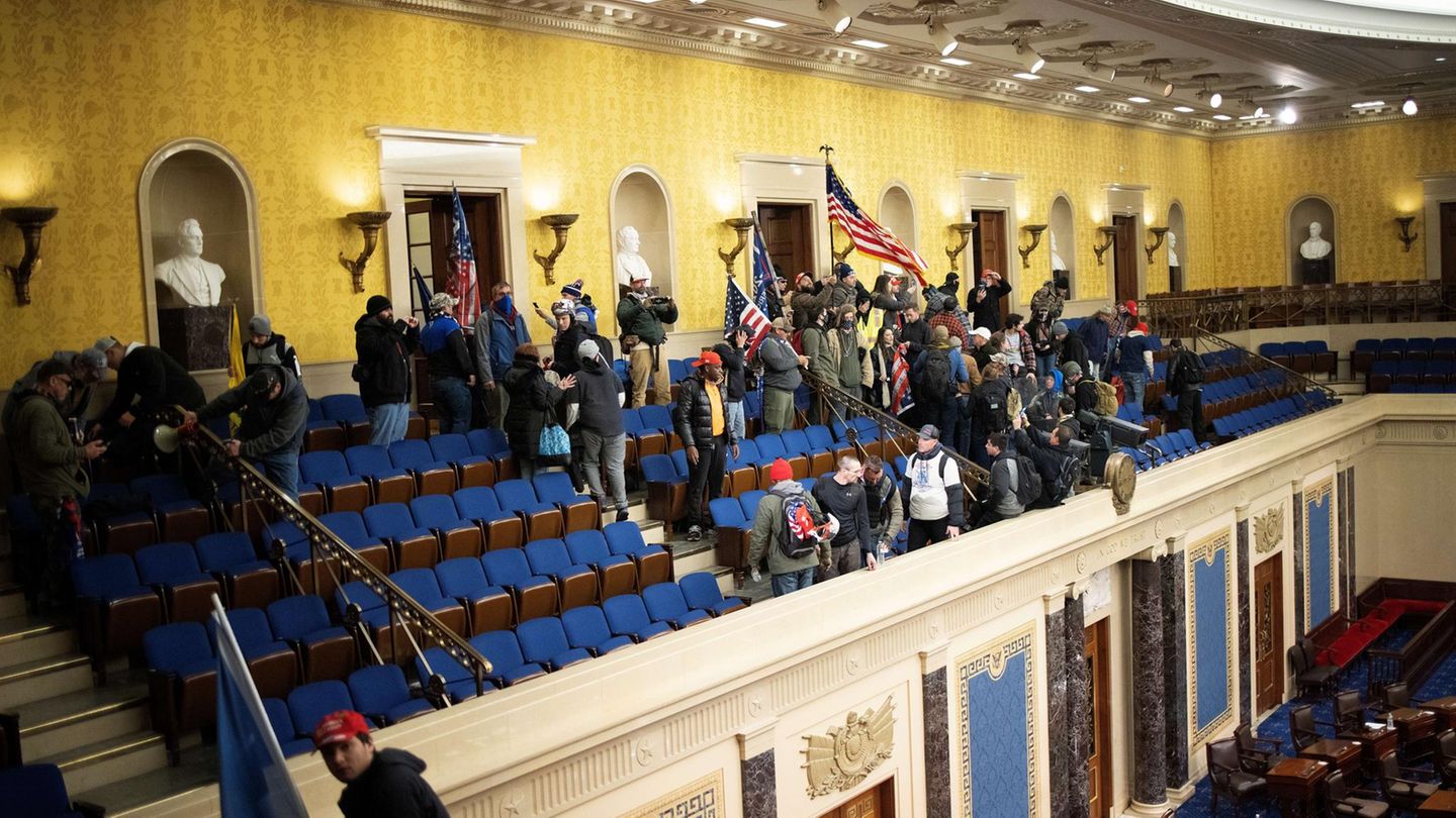 Der Pro-Trump-Mob hat das Herz der US-Demokratie erreicht und besetzt die Tribüne des Plenarsaals. Erst wenige Momente zuvor war es den Sicherheitskräften gelungen, die dort eingeschlossenen Abgeordneten in Sicherheit zu bringen