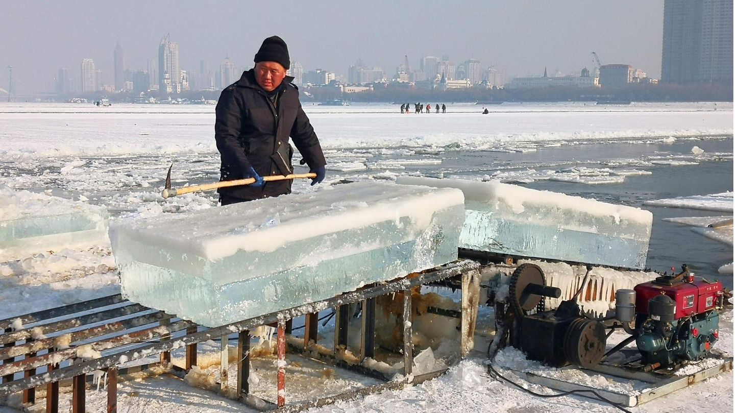 Für die Eisskuplturen und Gebäude schneiden Arbeiter zuvor Millionen Kubikmeter Eis aus dem nahegelegenen Fluss Songhua.