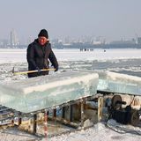 Für die Eisskuplturen und Gebäude schneiden Arbeiter zuvor Millionen Kubikmeter Eis aus dem nahegelegenen Fluss Songhua.