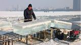 Für die Eisskuplturen und Gebäude schneiden Arbeiter zuvor Millionen Kubikmeter Eis aus dem nahegelegenen Fluss Songhua.