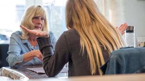 Zwei blonde Frauen diskutieren am Tisch
