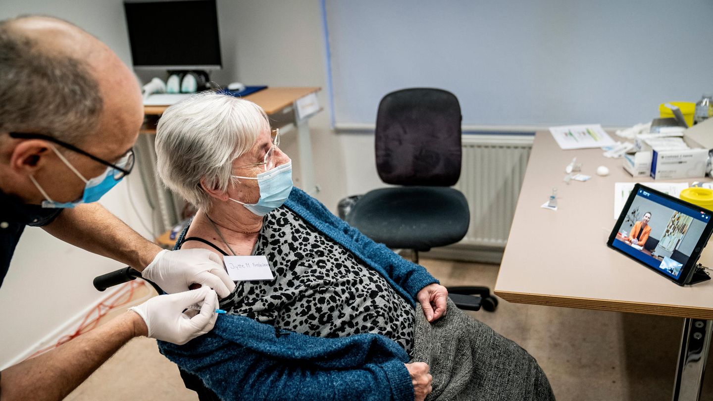 Eine ältere Frau wird von einem Arzt gegen Corona geimpft