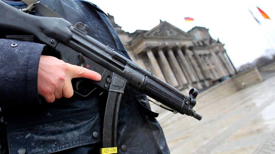 Ein bewaffneter Polizist steht vor dem Reichstagsgebäude