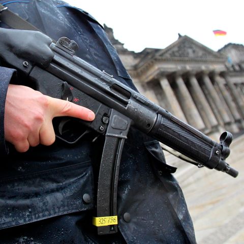 Ein bewaffneter Polizist steht vor dem Reichstagsgebäude