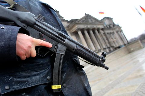 Ein bewaffneter Polizist steht vor dem Reichstagsgebäude