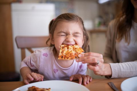 Kind isst Pizza