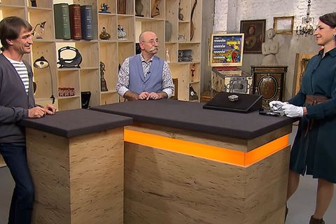 "Bares für Rares"-Expertin Wendela Horz erklärt Moderator Horst Lichter und Besitzer Dirk Rudel (l.) die Herkunft der Silberdose.