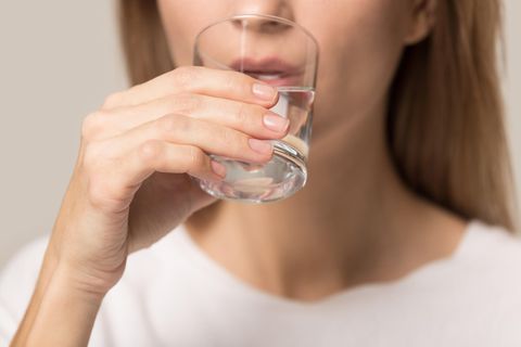 Eine Frau trinkt Wasser aus einem Glas