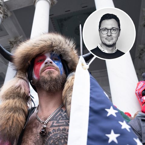 Mann mit Hörnern, Fellen und Amerika-Flagge vor Kapitol