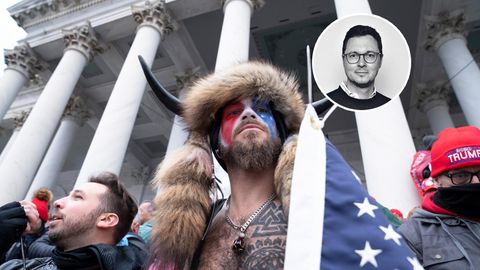 Mann mit Hörnern, Fellen und Amerika-Flagge vor Kapitol