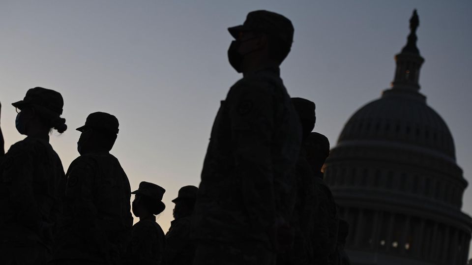 Soldaten Washington Im Gegenlicht sind Konturen von Uniformierten mit Käppis auf dem Kopf neben der Kuppel des US-Kapitols zu sehen