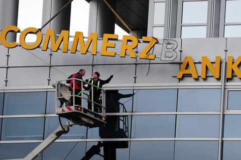Arbeiter demontieren den Commerzbank-Schriftzug an einer Filiale in Frankfurt
