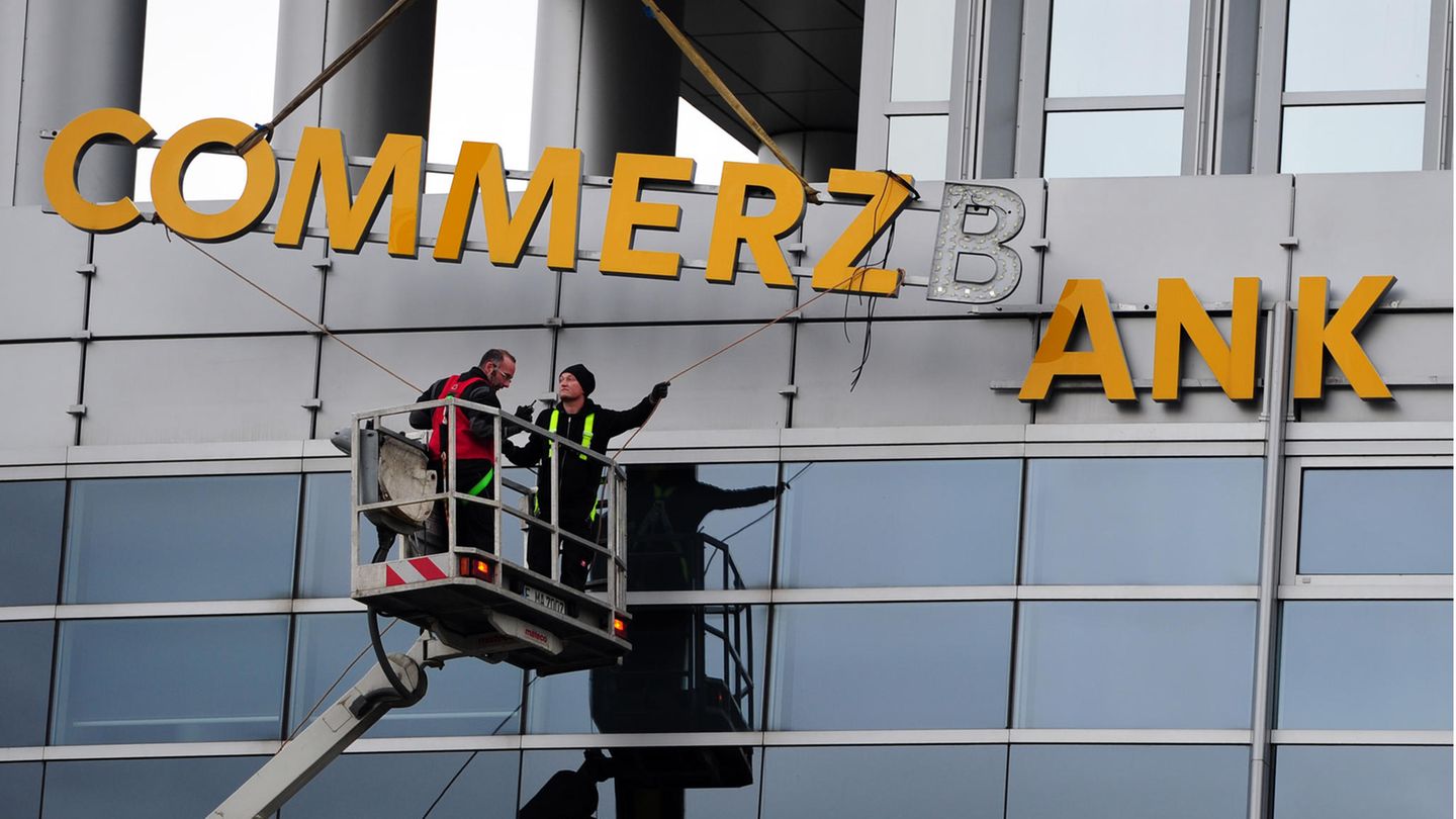 Arbeiter demontieren den Commerzbank-Schriftzug an einer Filiale in Frankfurt