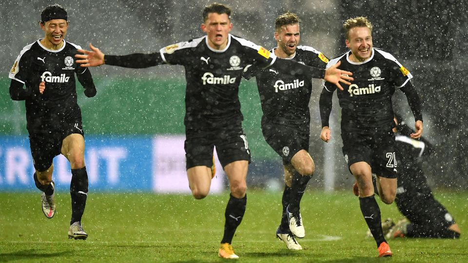 Spieler von Holstein Kiel laufen jubelnd auf die Kamera zu