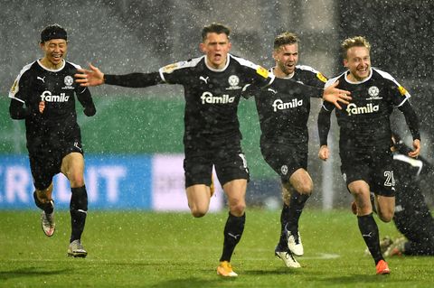 Spieler von Holstein Kiel laufen jubelnd auf die Kamera zu